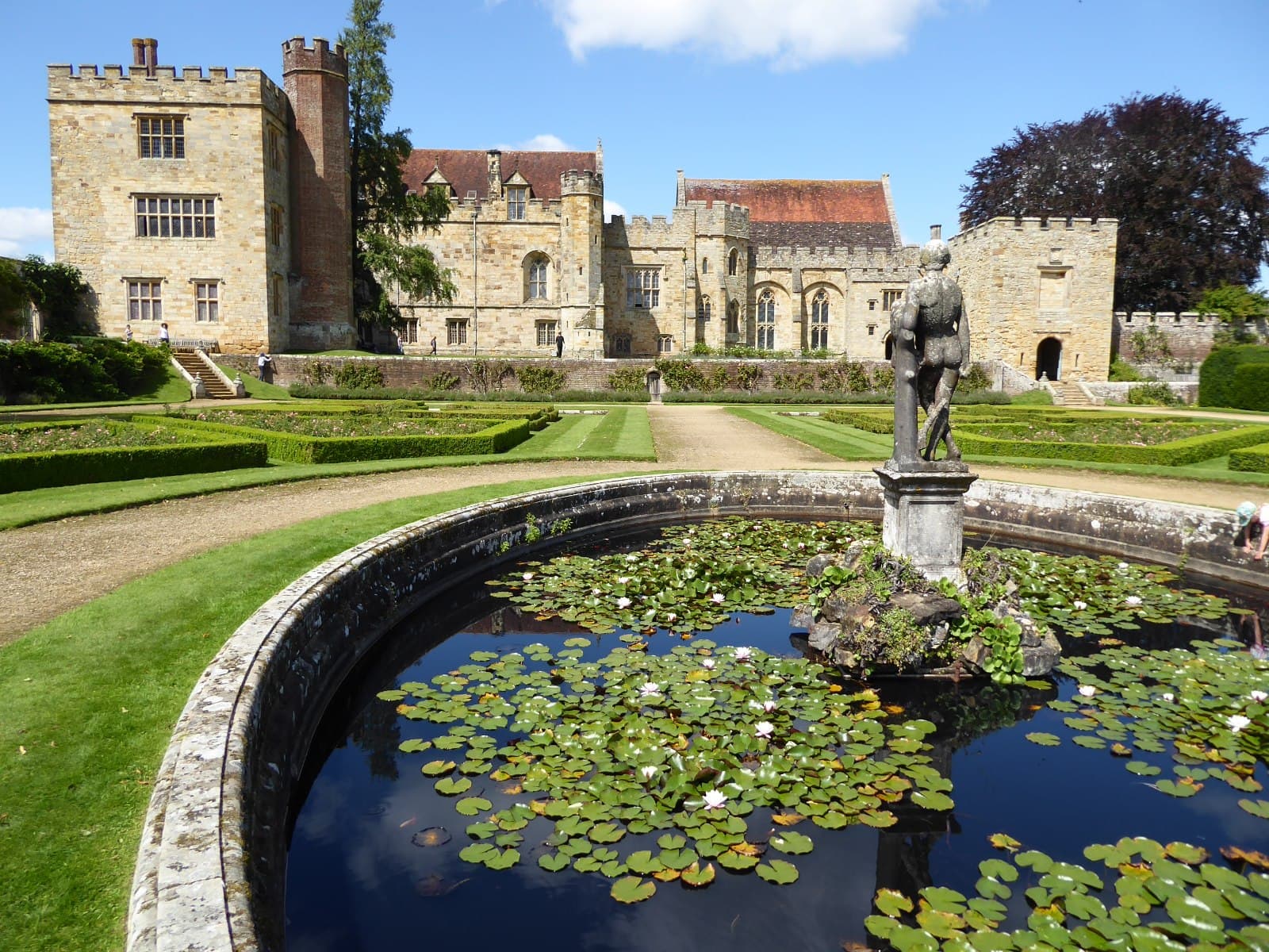Lily pond and statue in the gardens at Penshurst Place, with the house behind